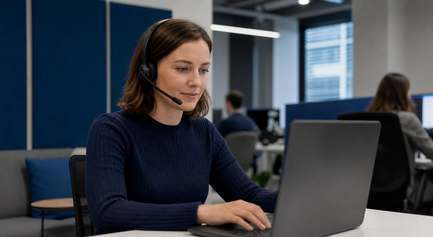 Pracowniczka obsługująca rozmowę PBXCenter na laptopie przez zestaw słuchawkowy